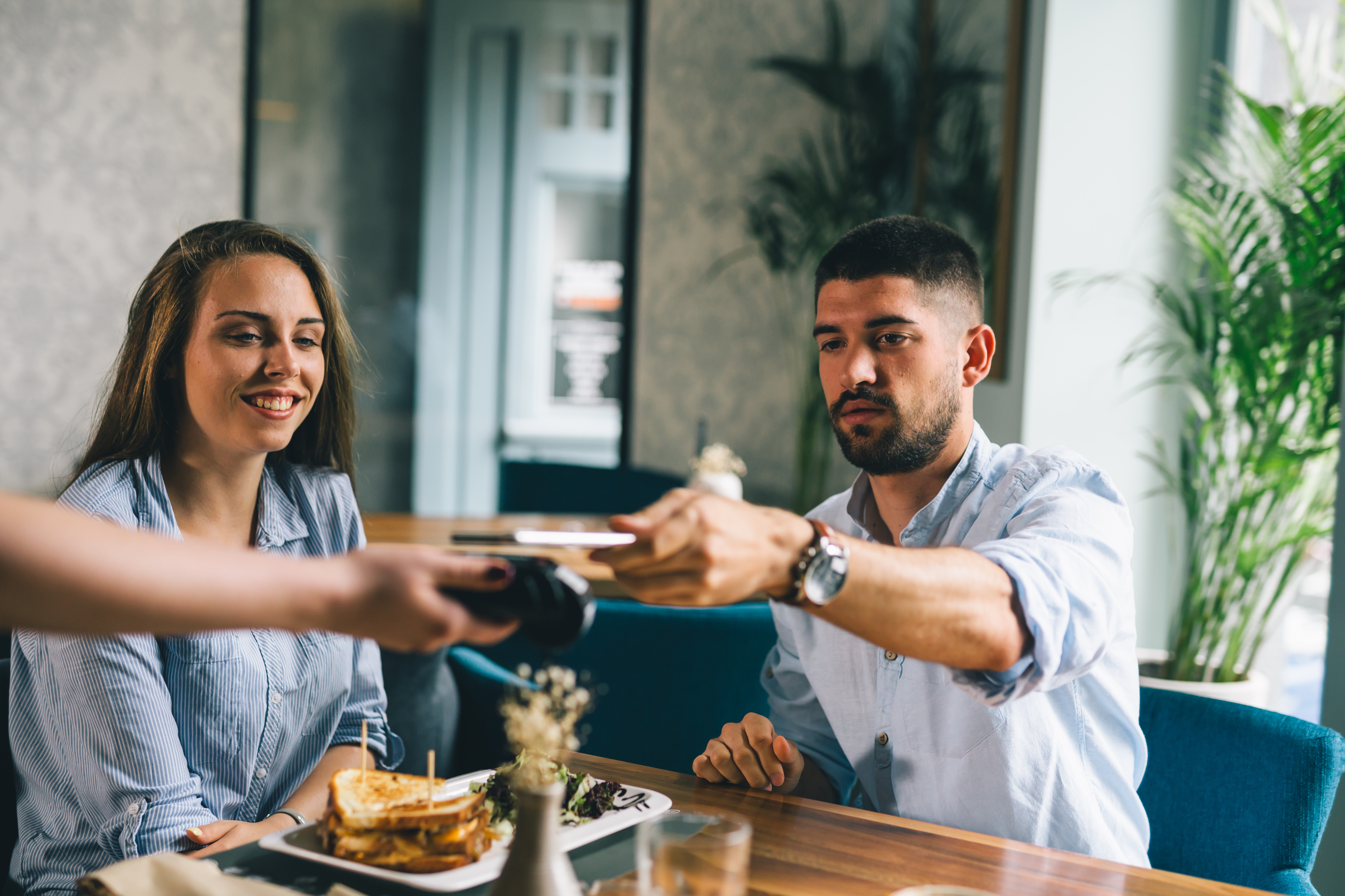  A man pays for dinner using contactless payment using funds from his free checking account
