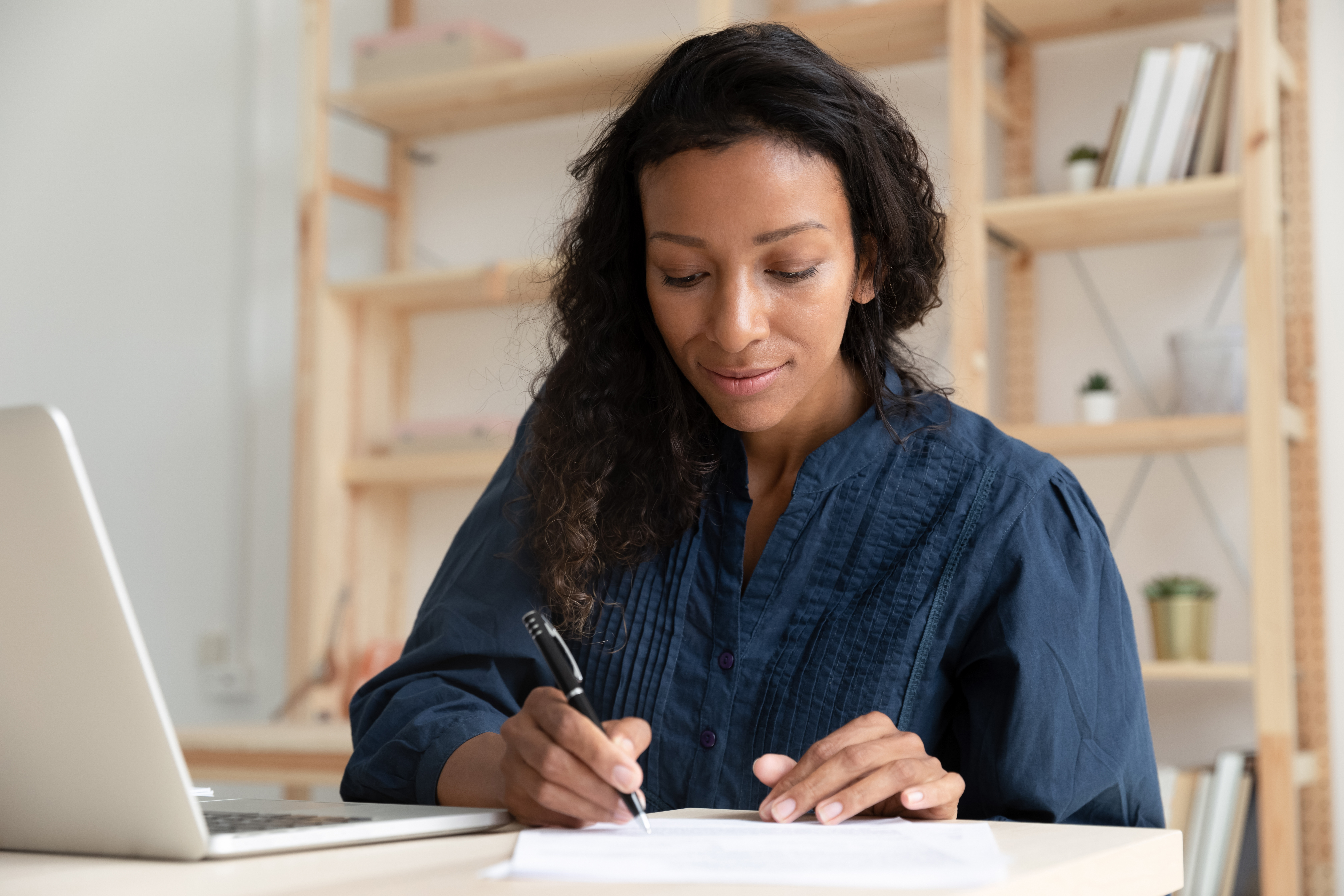 A woman writing a check from her regular checking account.
